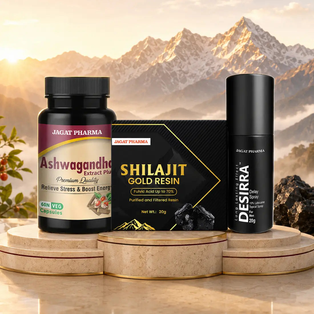 Three JAGAT PHARMA products displayed together on a set of round stone pedestals against a dramatic mountain backdrop: an Ashwagandha supplement bottle, a black Shilajit Gold Resin box, and a black Desirra spray bottle.