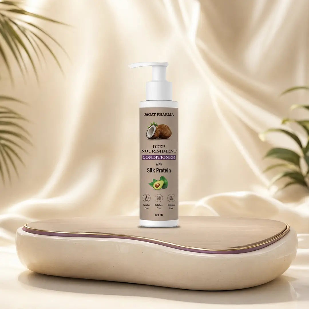 A pump bottle of Jugal Pharma Deep Nourishing Conditioner with Silk Protein stands on a curved beige tray against a draped cream fabric backdrop with soft plant leaves at the sides.